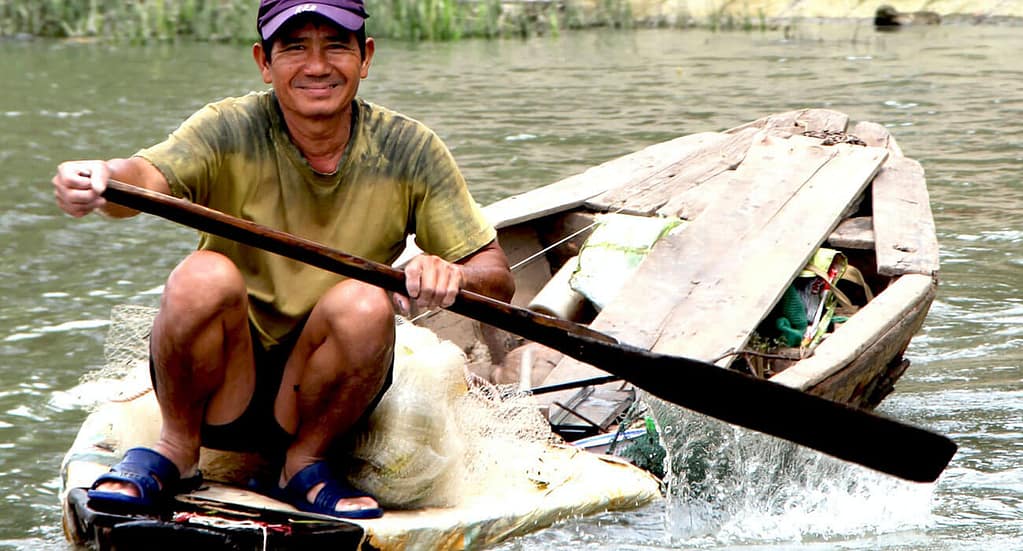 A worker along the Mekong Delta - happy despite hardship